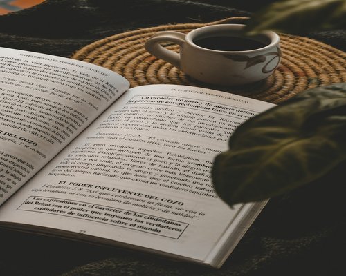 Libro y café sobre la mesa, símbolo de descanso